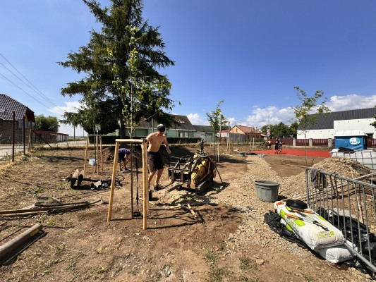 třetí dekáda června 2026 - sázení stromů a dokončování pryžového povrchu