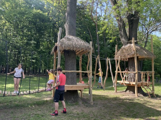 Vyžití dětí na hřišti mezi stromy